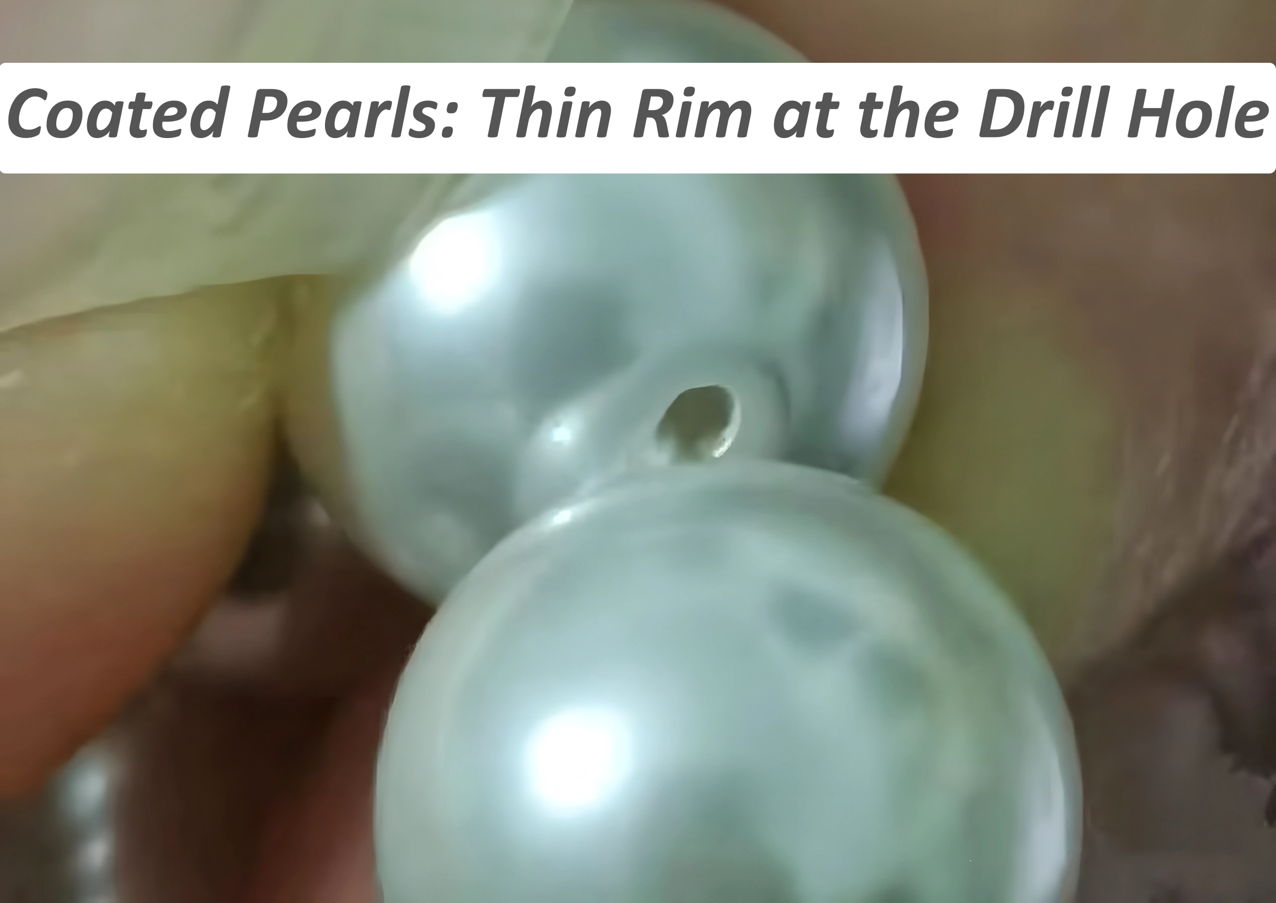 Close-up of coated pearl drill hole edge showing thin layer separation
