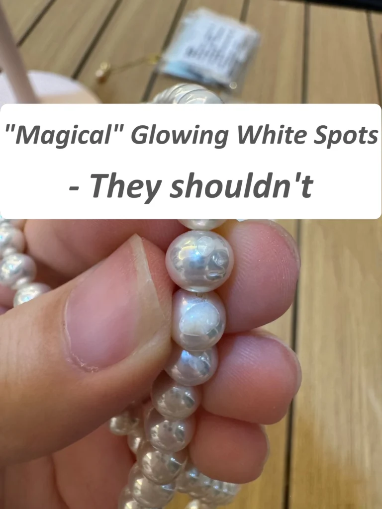 Coated pearl with unnatural shine on white spots where nacre is missing